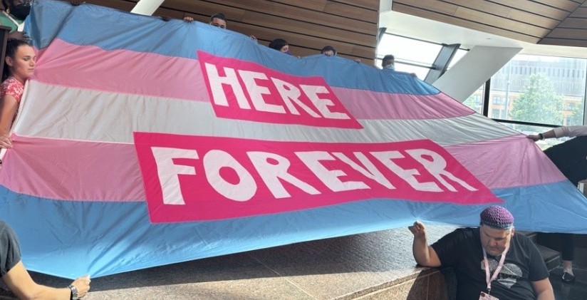 Here Forever Banner held by community volunteers at 2025 Trans Equity Summit