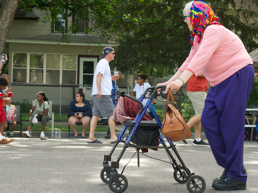 Elderly person walking down street.