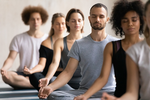 Several people meditating in yoga class