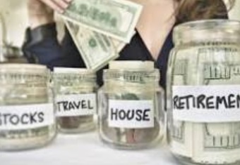 Money in jars labeled stocks, travel, house and retirement