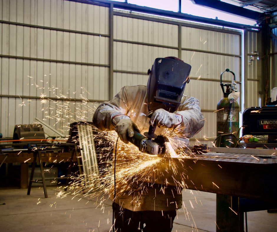 A welder in a large garage