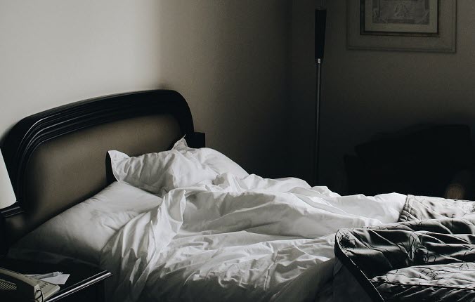 An unmade bed in a hotel room
