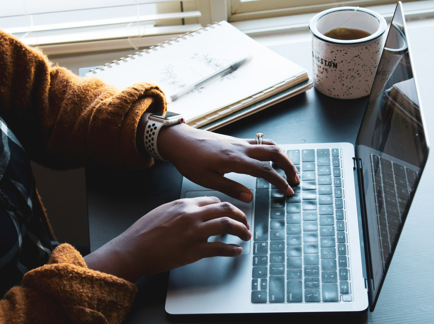 Hands typing at laptop