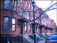 Color photo from 2006 looking at red brick rowhouses from the street.