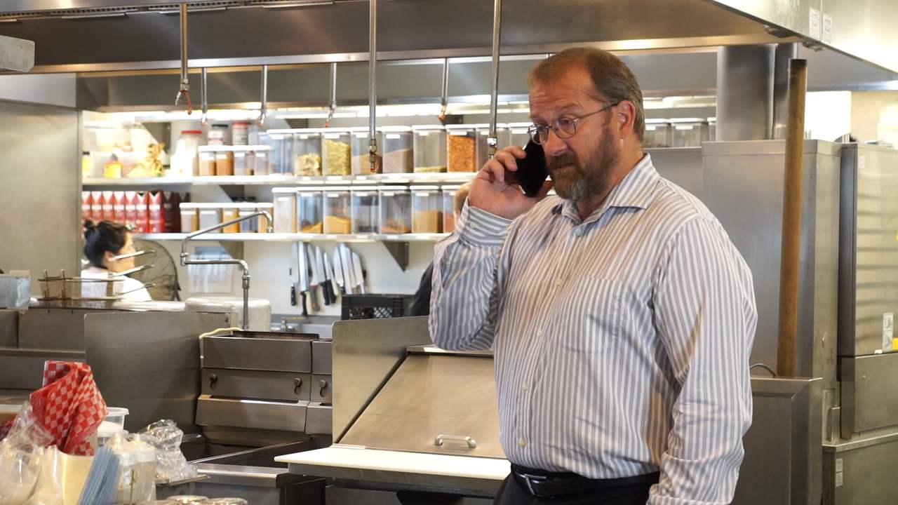 A restaurant manager talking on the phone