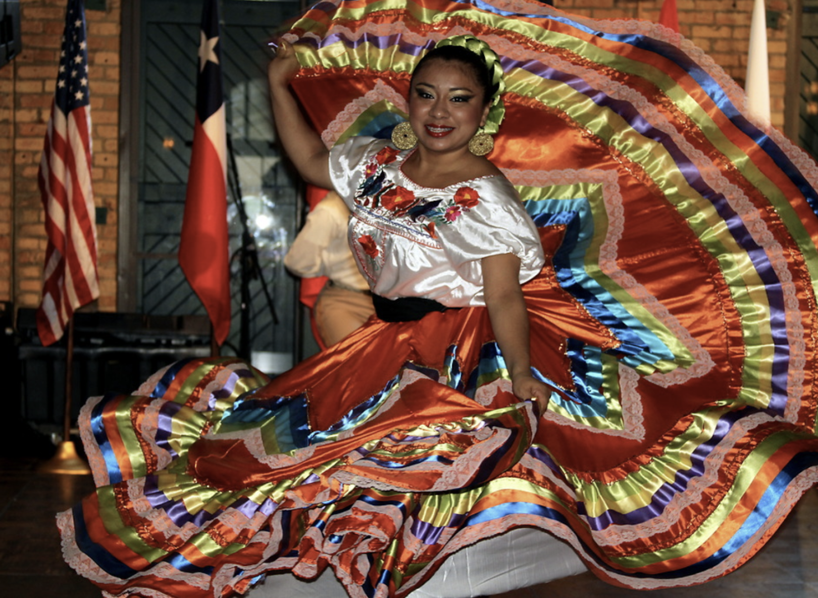 a woman dancing in a colorful skirt